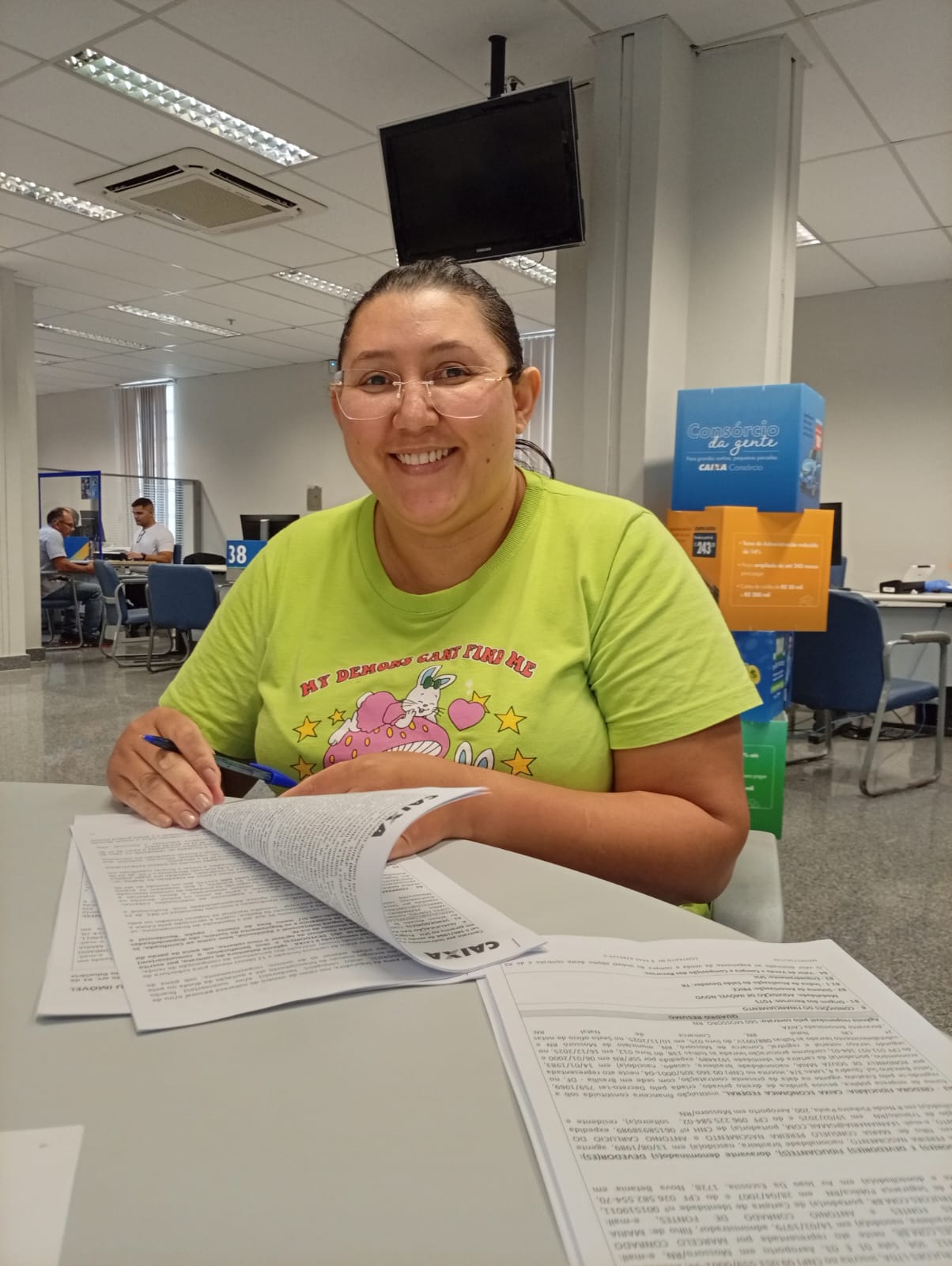 Cliente sorrindo durante assinatura do contrato