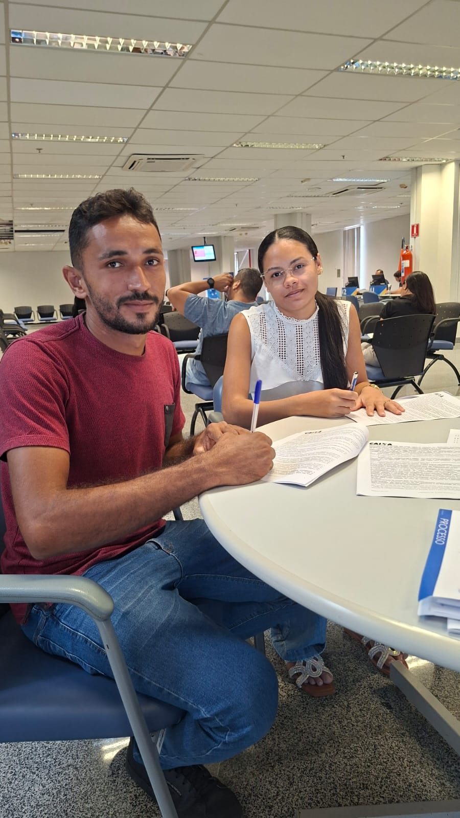 Casal assinando contrato de financiamento na Caixa