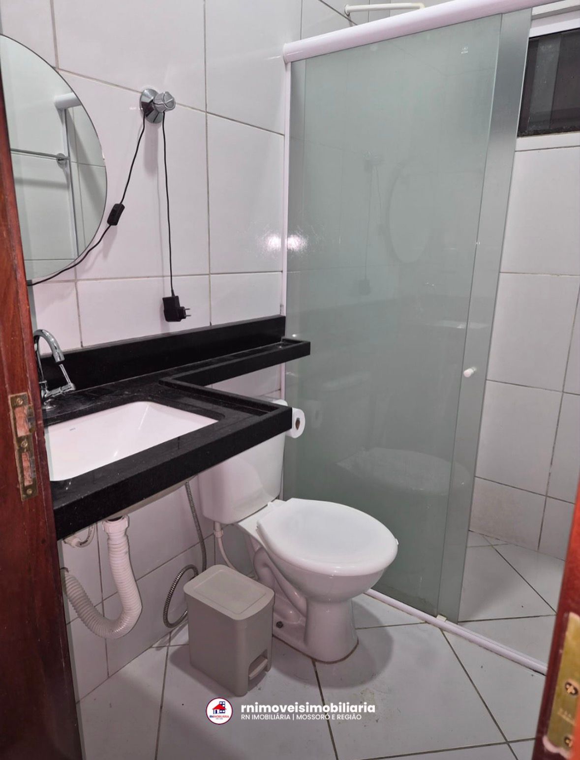 Banheiro com box de vidro e bancada em granito